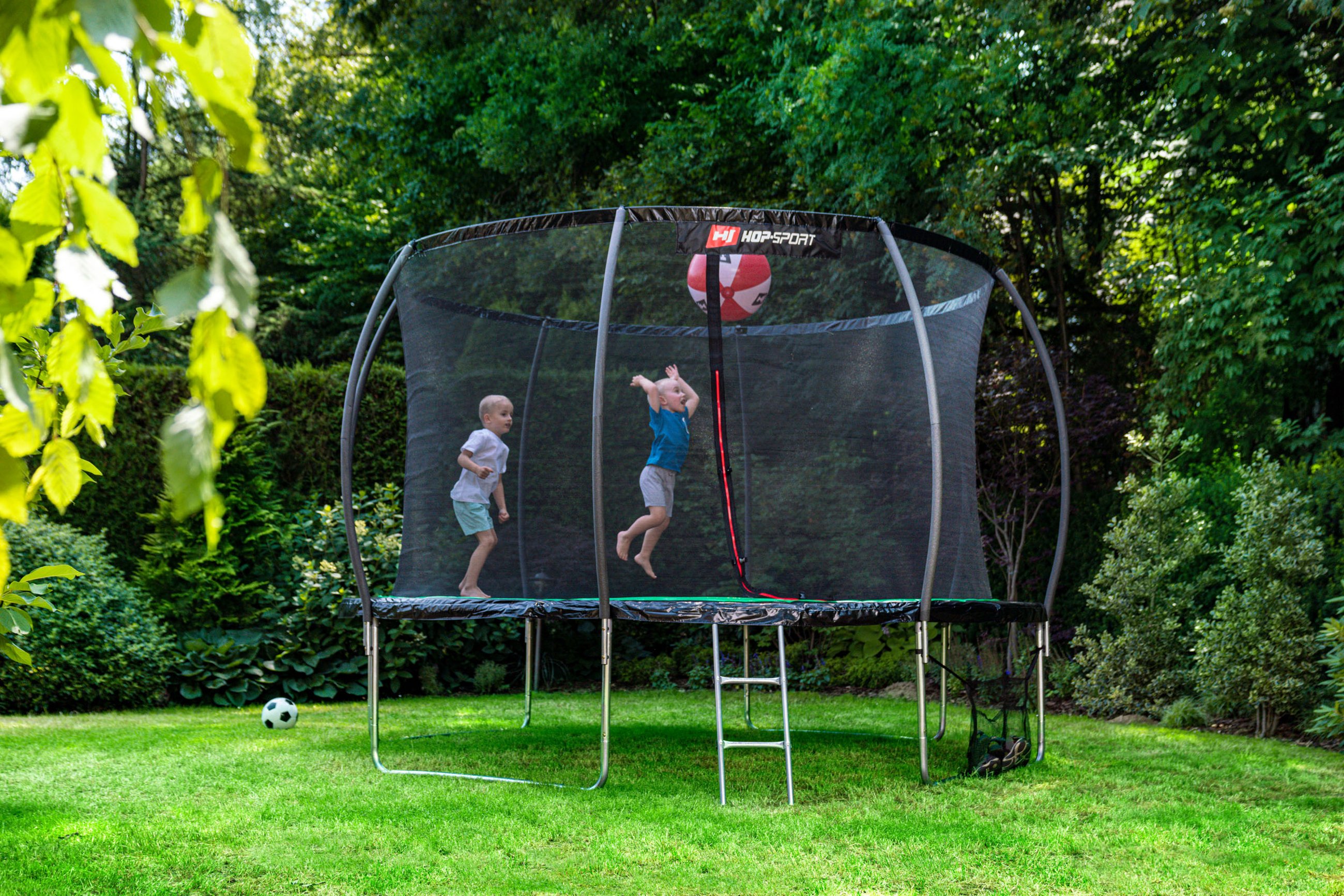 deti skákajúce na záhradnej trampolíne Hop-Sport v záhrade